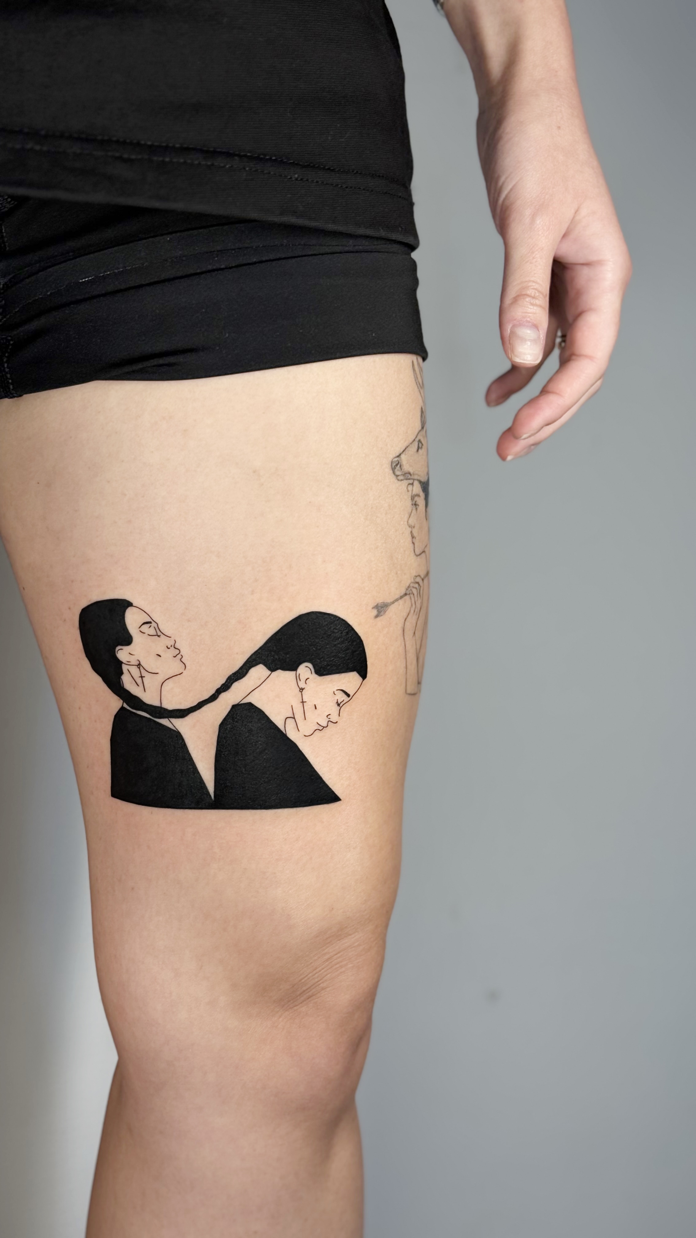 Blackwork queer thigh tattoo of two women with intertwined braids — lesbian and sapphic fine line work portraiture in illustrative graphic style by Jane Again Tattoo, Mexico City.